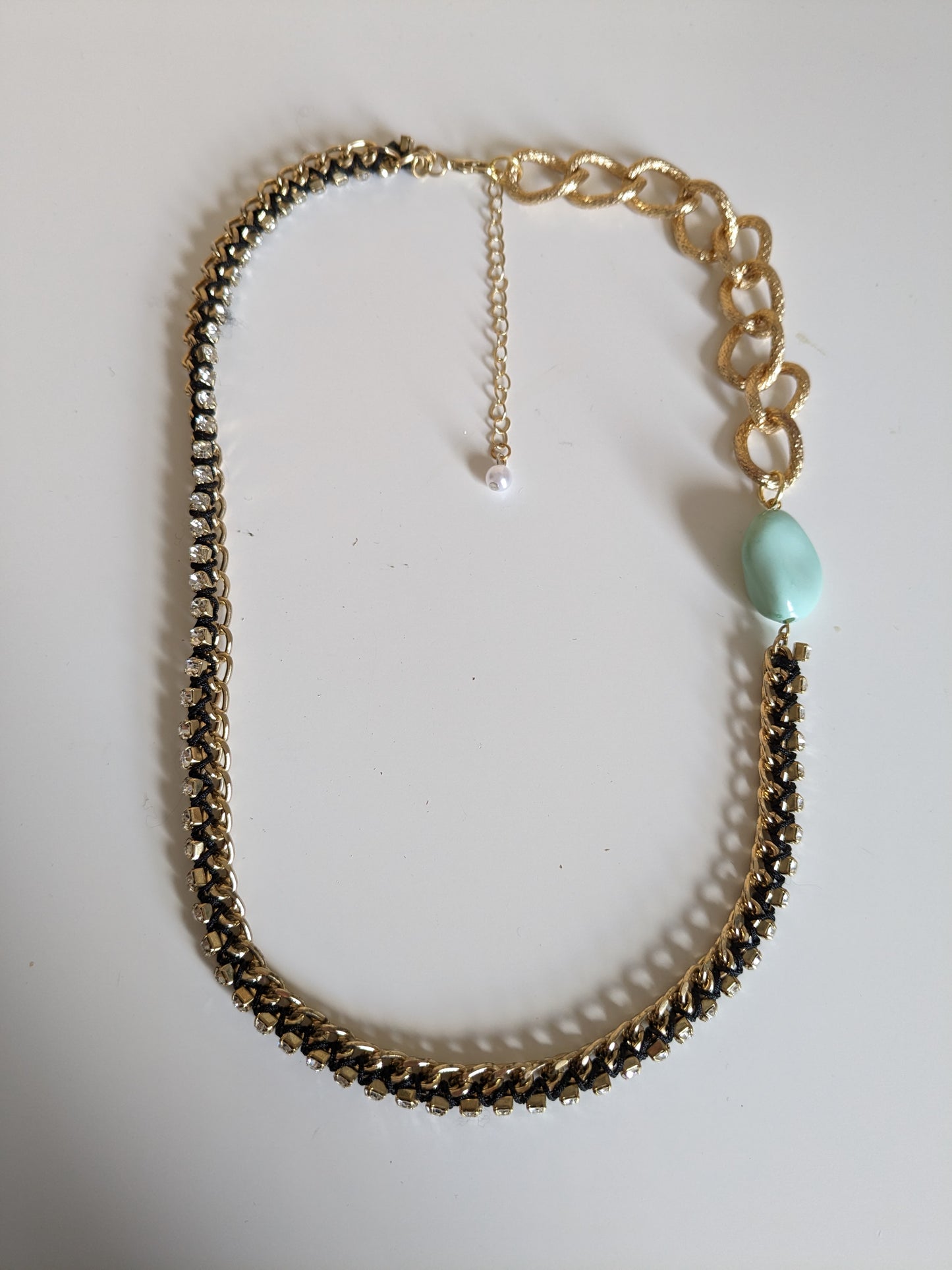 Statement necklace made from two different gold tone chains with a ribbon threaded through and a chunky plastic mint vintage bead.