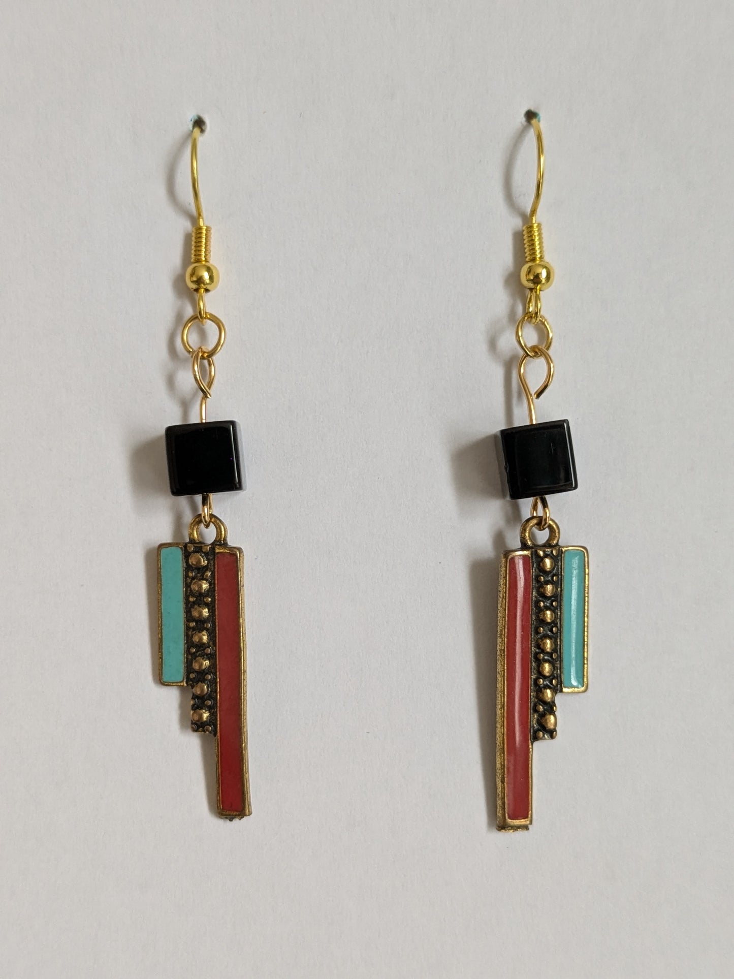 Eye-catching dangle earrings made with blue and red striped modernist art deco inspired gold tone charms and black plastic cube beads, with new gold plated wires.