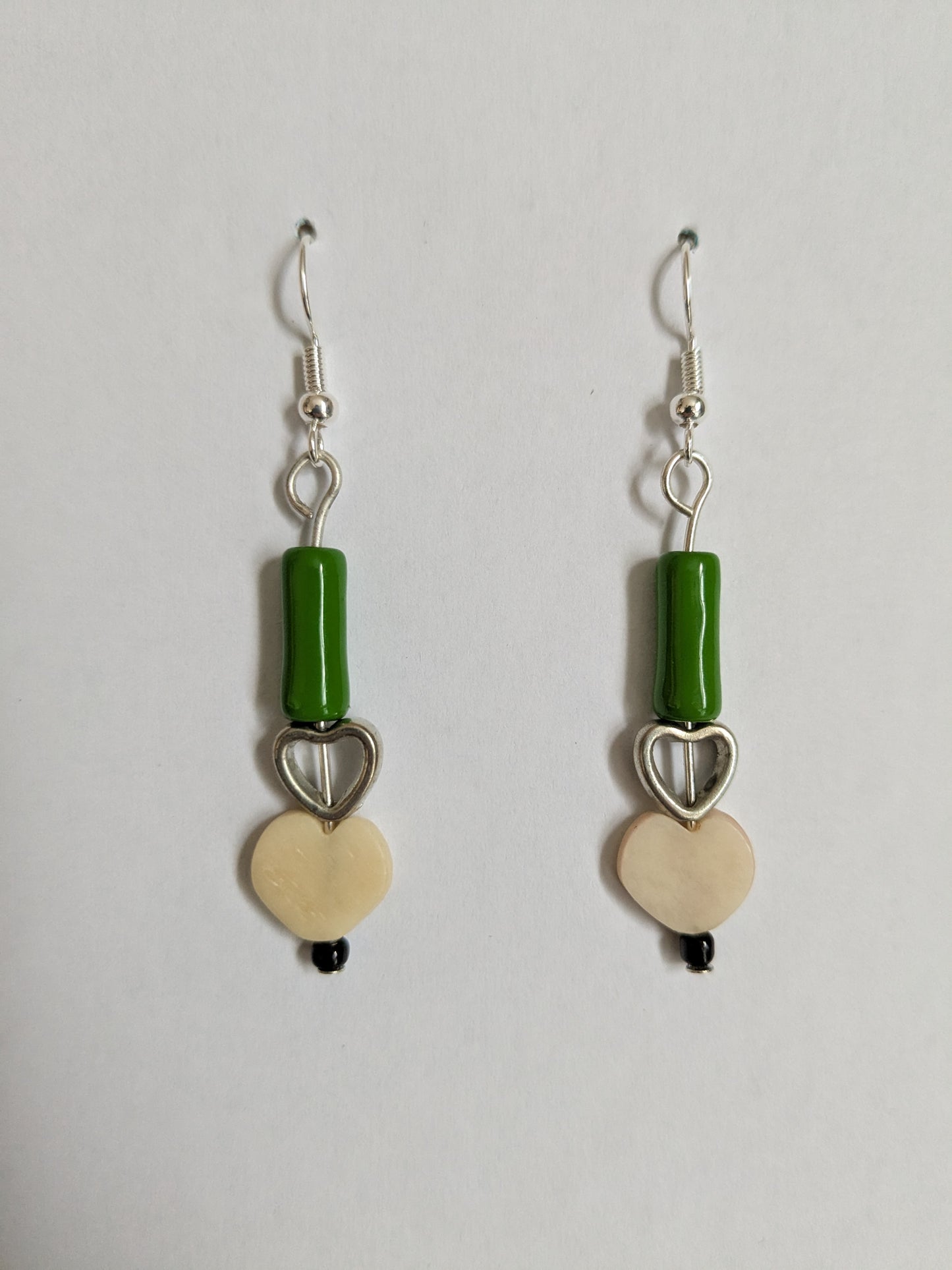 Dangle earrings made from two vintage heart beads and a green ceramic bead, with new silver-plated wires.