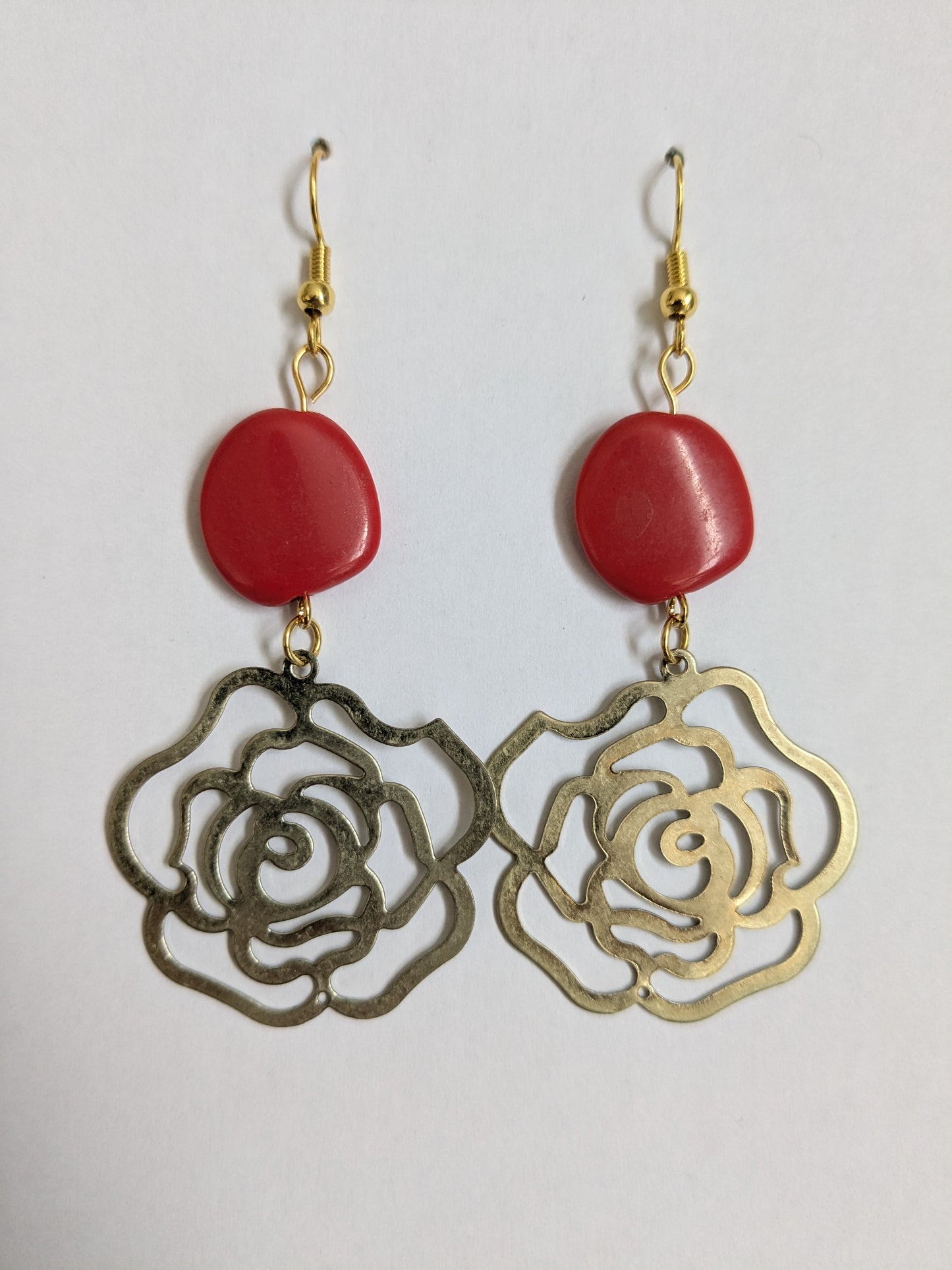Dangle earrings made with vintage brass rose charms, red beads, with new gold-plated wires.