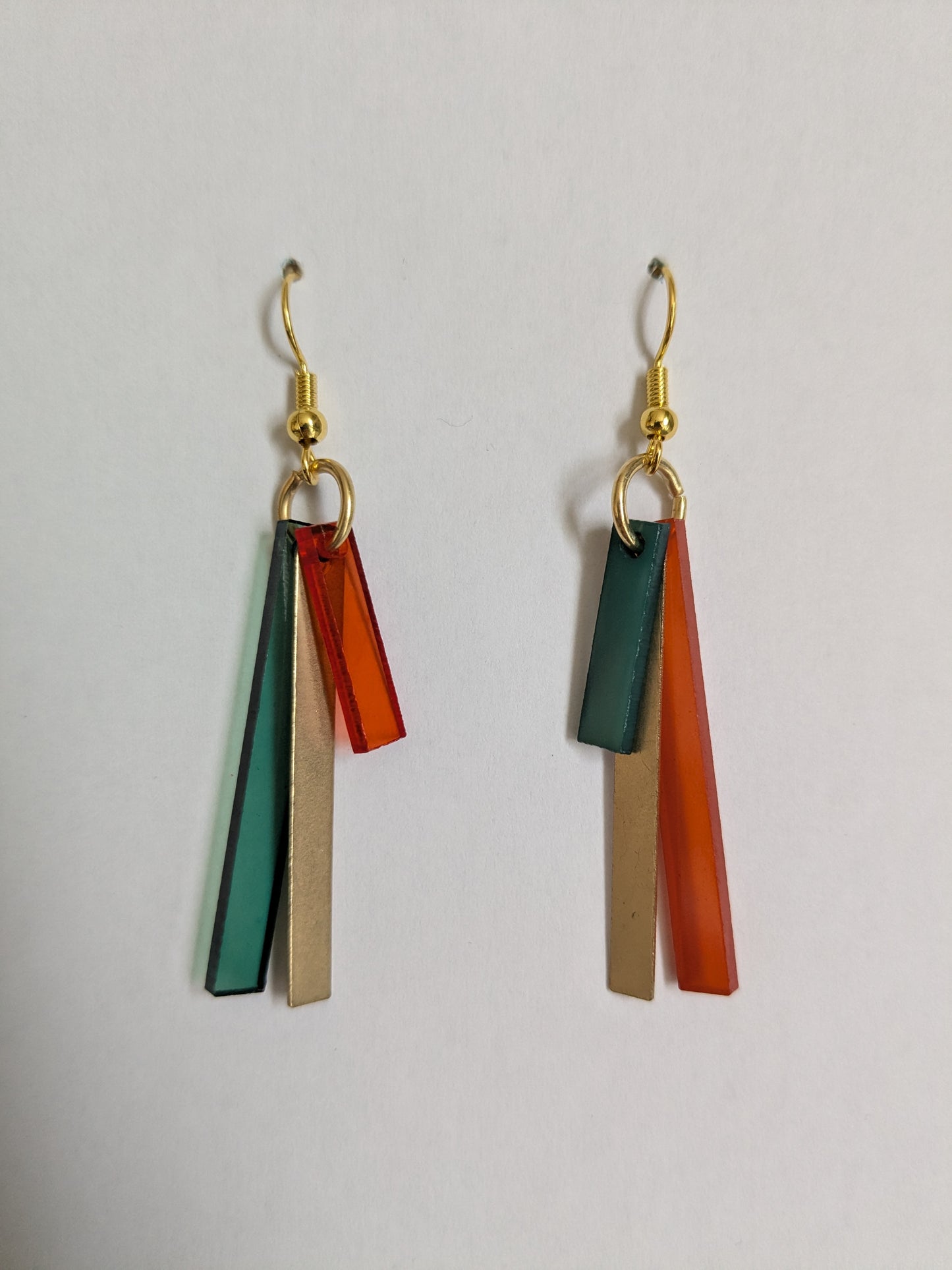 Colourful dangle earrings made from orange and green acrylic and brass bars, with a new gold-plated wire. 
