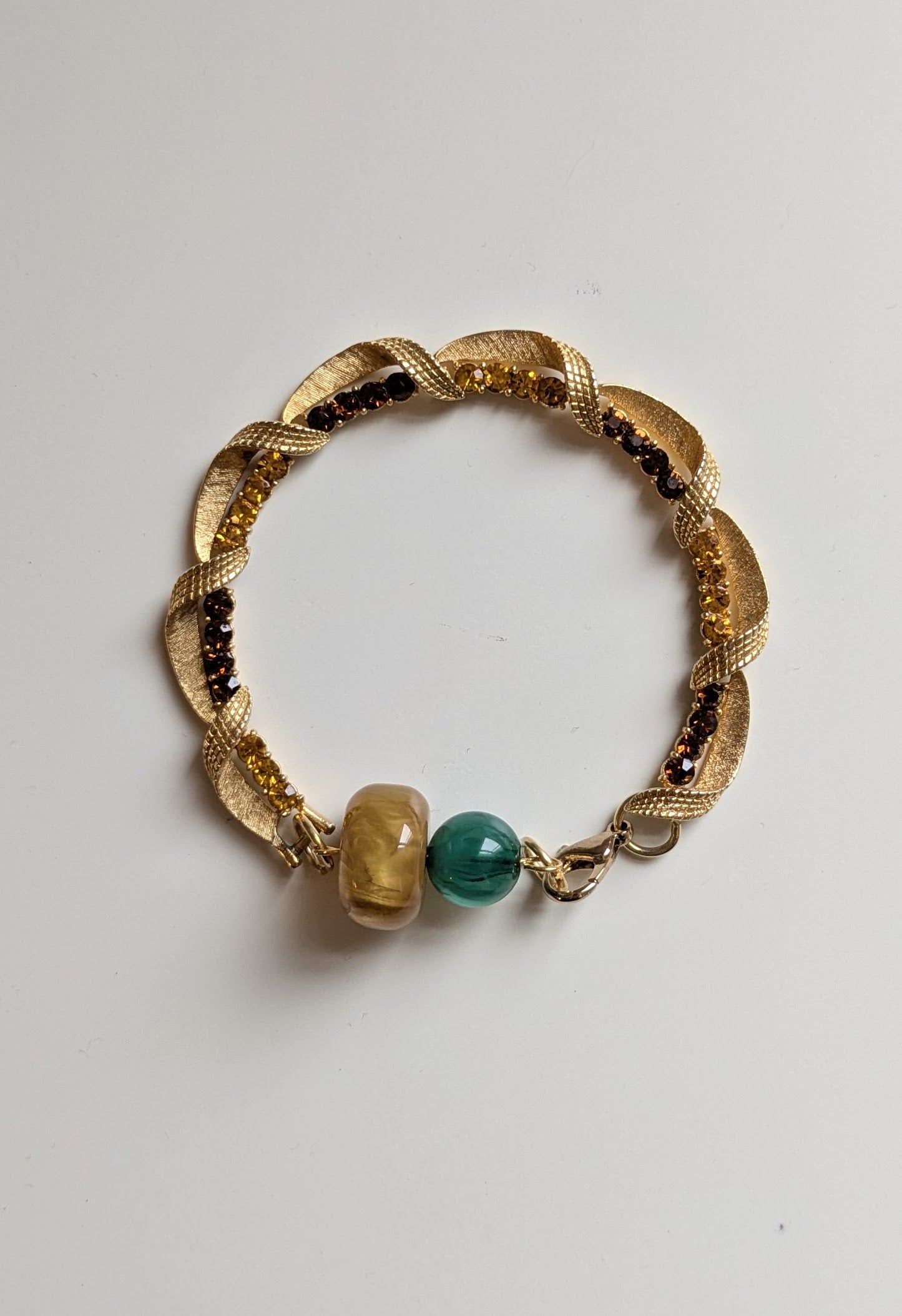 Elegant bracelet made from vintage gold tone jewelled links and two vintage beads in yellow and green.