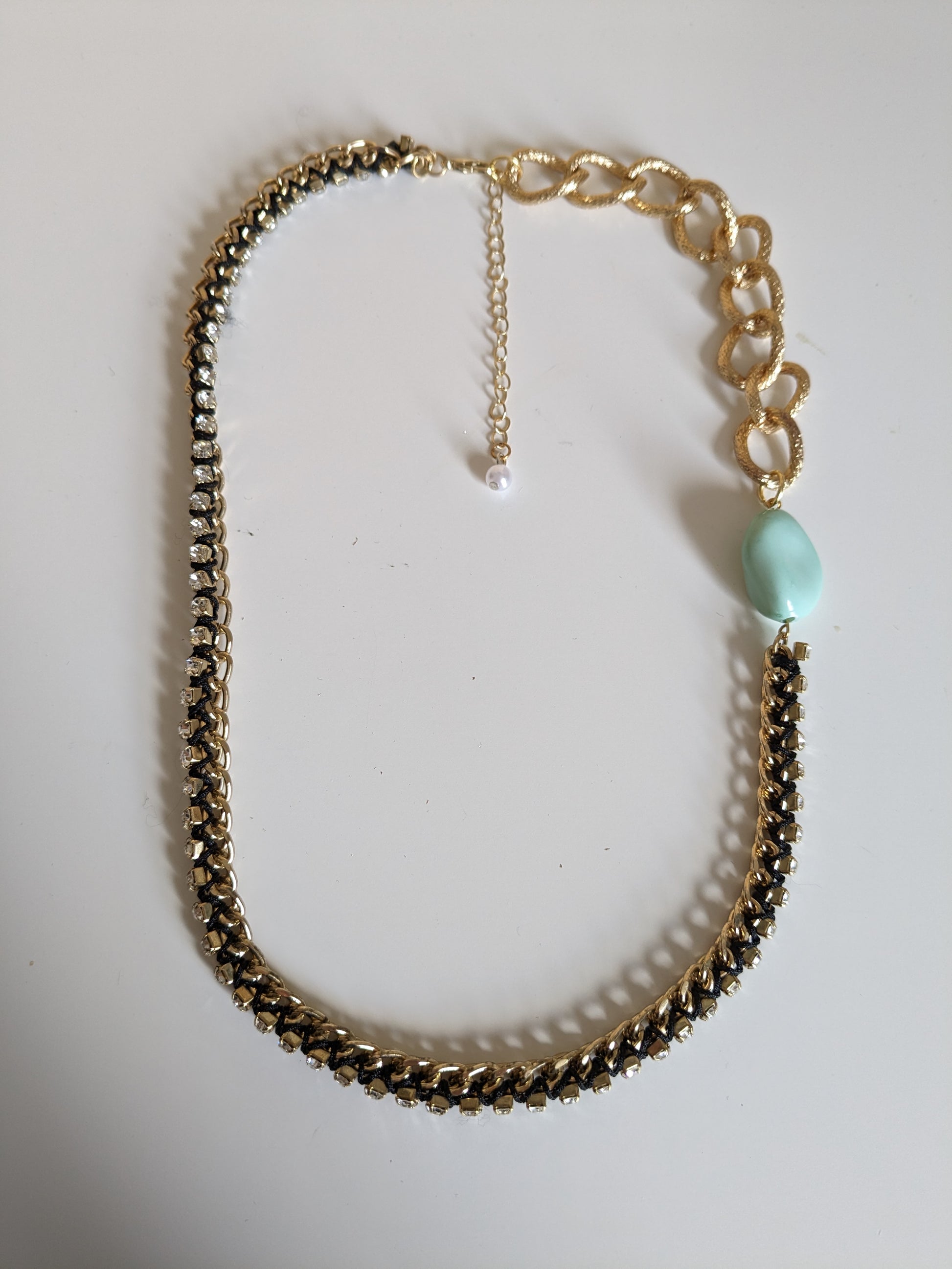 Statement necklace made from two different gold tone chains with a ribbon threaded through and a chunky plastic mint vintage bead.