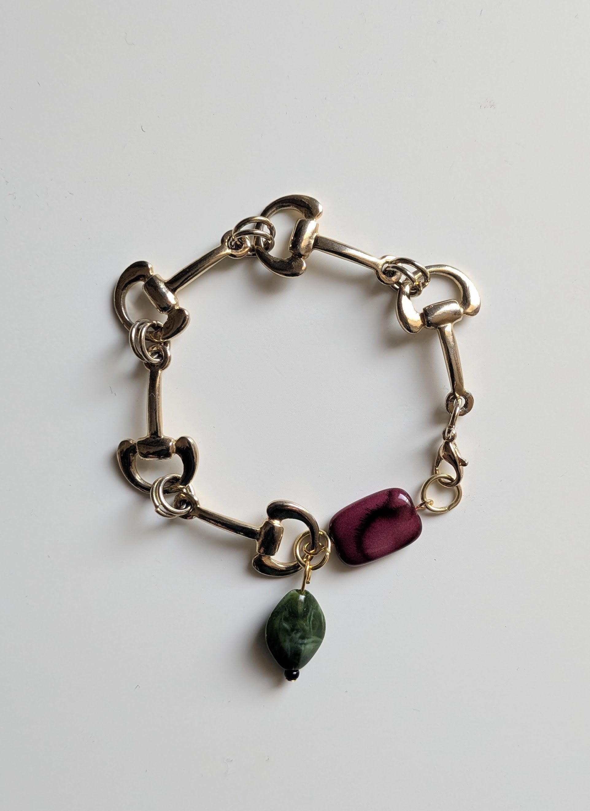 Elegant bracelet made with vintage gold tone link chain, and two vintage marble-effect plastic beads in burgundy and dark green.