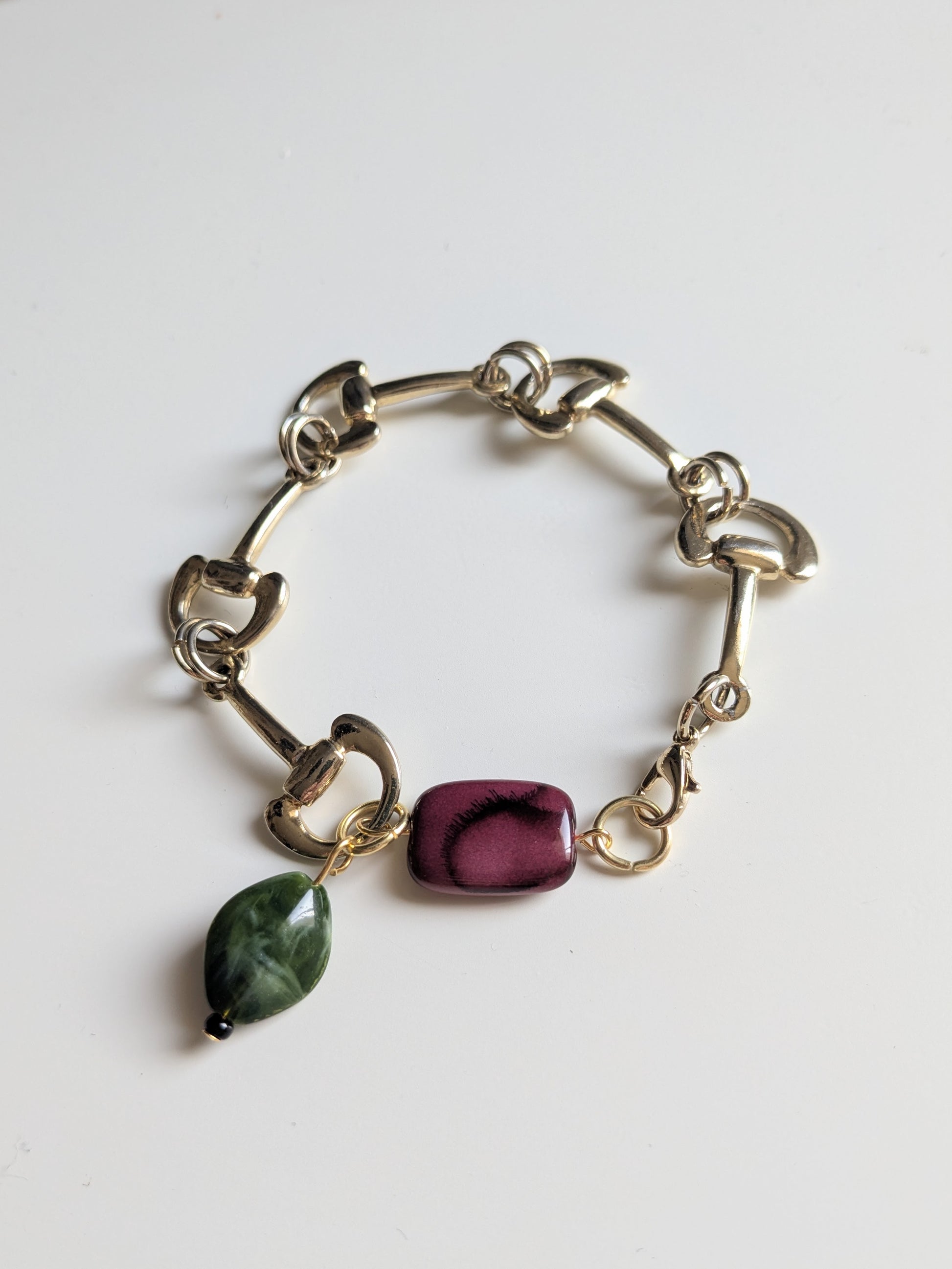 Elegant bracelet made with vintage gold tone link chain, and two vintage marble-effect plastic beads in burgundy and dark green.