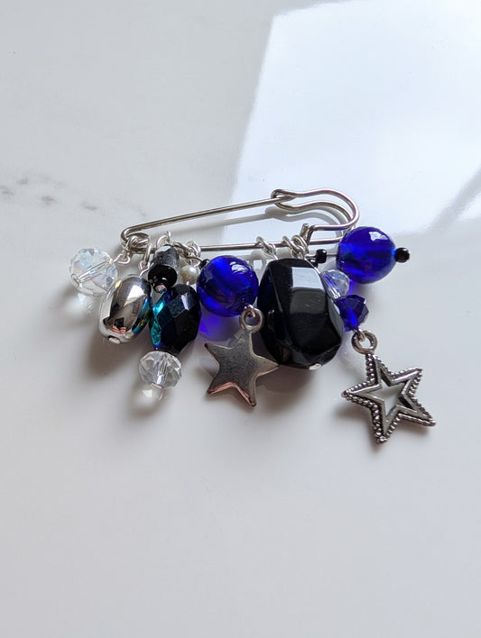 Beaded pin brooch with stars and crystals on a white background