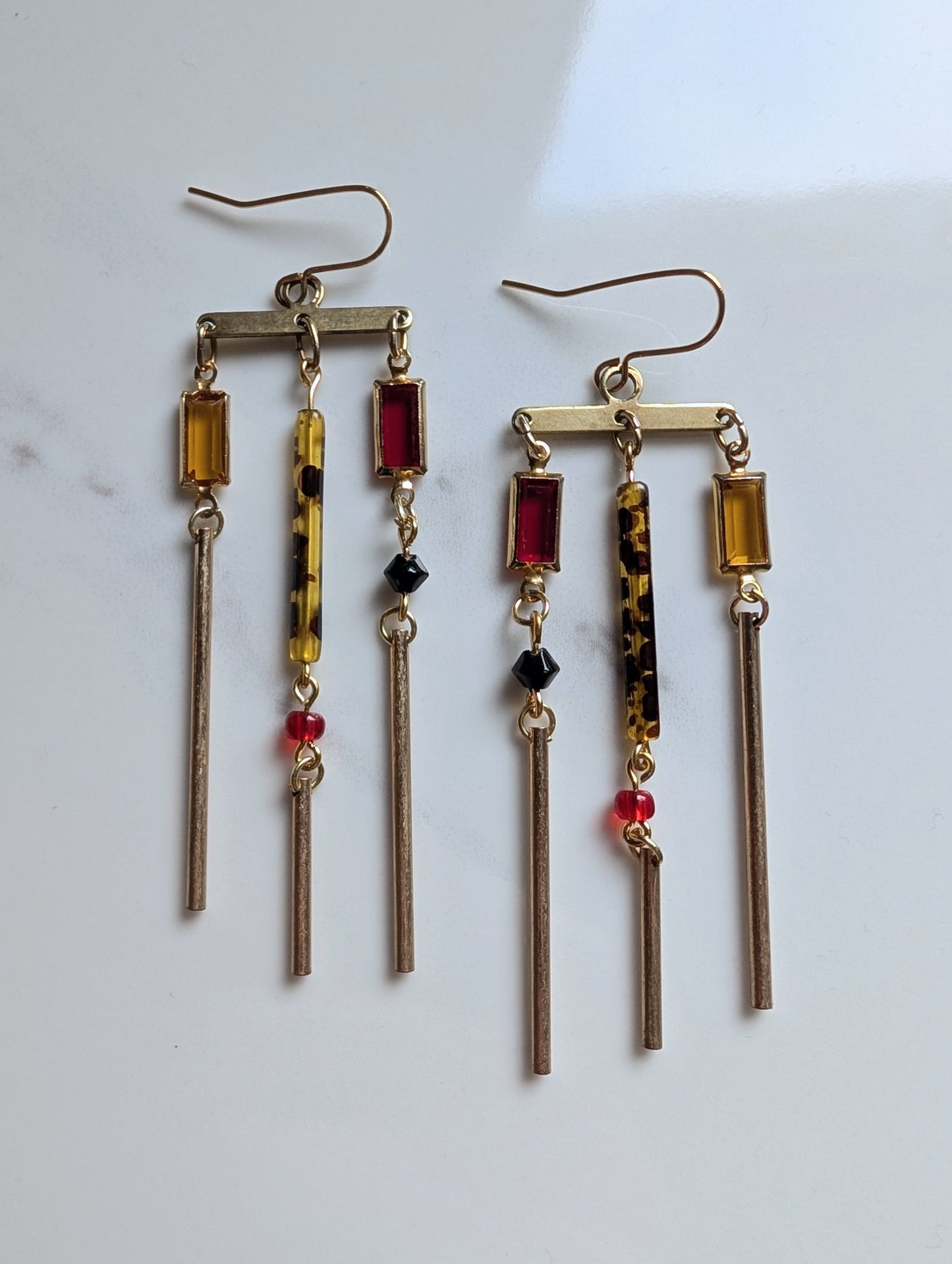 Pair of dangling earrings with colorful beads on a white background
